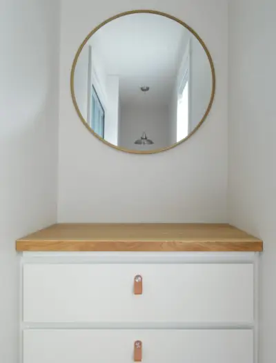 Commode Ikea Malm avec comptoir de boucher et poignées en cuir sous le miroir rond