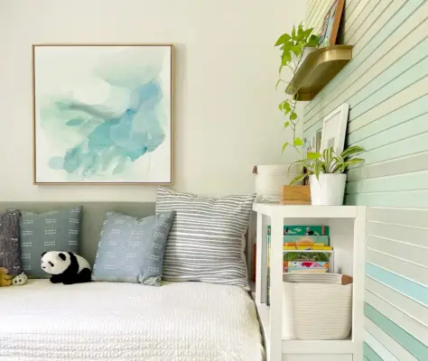 Petite chambre d'enfant avec tête de lit rembourrée et bibliothèque avec mur d'accent coloré