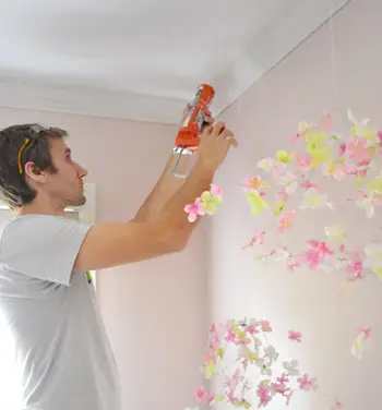 John adicionando calafetagem contra o teto onde a moldura da coroa tem uma pequena lacuna