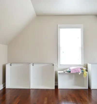 Chambre avec plafond mansardé et armoires Ikea en construction, avec une fille