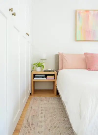 Quarto com armários Ikea brancos ao lado da cama king-size branca com mesa de cabeceira DIY