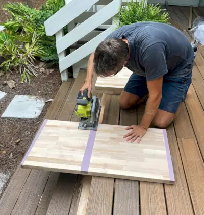 John cortando bloco de açougueiro usando serra circular na varanda