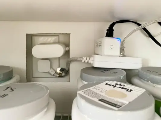 Detalhe de plugues e fios na unidade de armazenamento Ikea Besta