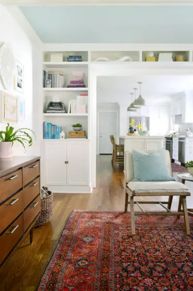 witte ingebouwde boekenplanken rond een deuropening in de woonkamer