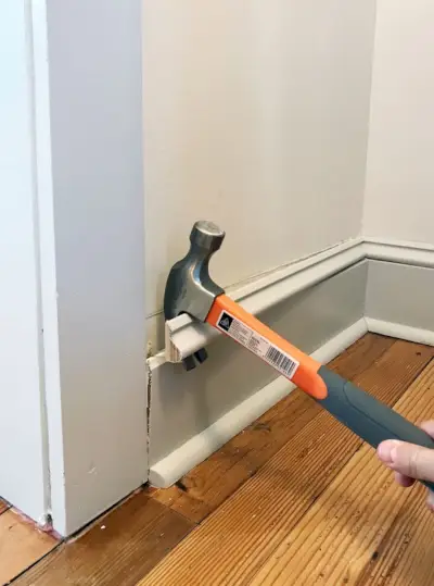 čekić prying off baseboard molding in panty