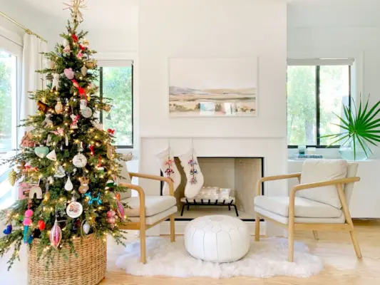 Moderne slaapkamer met kerstboom en kousen op witte open haard