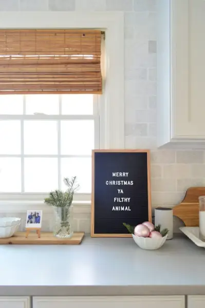 Cartellone nero sul bancone della cucina con Buon Natale Ya Filthy Animal