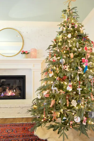 Faux sapin de Noël de 7 pieds sur un tapis traditionnel à côté d'un foyer au gaz