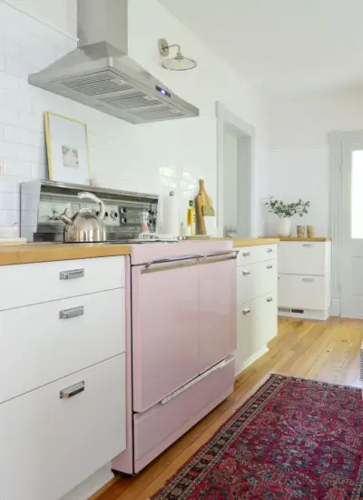 Cuisine de maison de plage avec poêle rose et dosseret de métro blanc