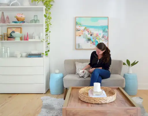 Sherry assise sur un canapé avec un chihuahua à côté d'une étagère en métal blanc