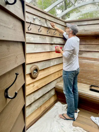 John Brushing Behr Mancha sólida em paredes de chuveiro externo de cedro