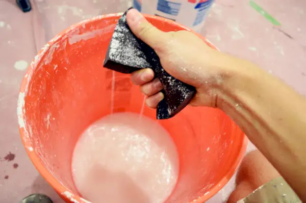 water uit het schuurblok knijpen als een spons in een emmer