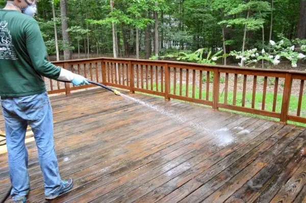 John enjuagando el limpiador de terrazas con una manguera de jardín