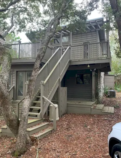 Avant Photo du côté de la maison avec escalier menant au porche à l'étage et peint en marron