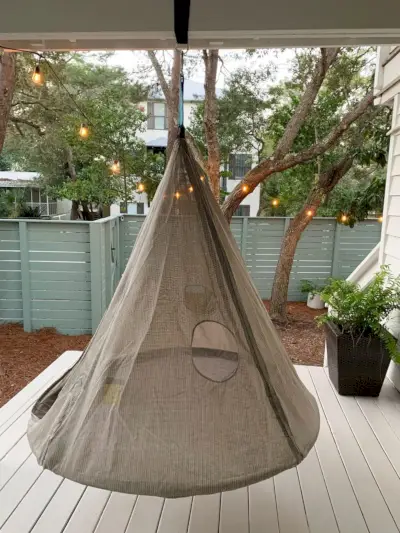 Hangende kegelvormige tent met gaas boven de geschilderde verandavloer