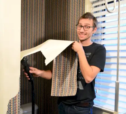 John utilise un bateau à vapeur pour enlever le papier peint dans la salle de bain