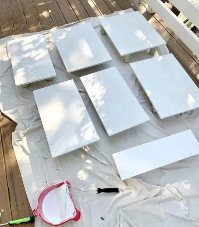 Portas de armário colocadas sobre pano com camada de primer branco secando