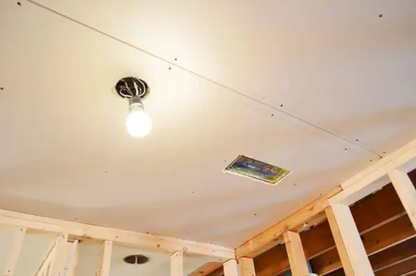 gipsplaat opgehangen in plafond met gat voor licht en HVAC-ventilatie