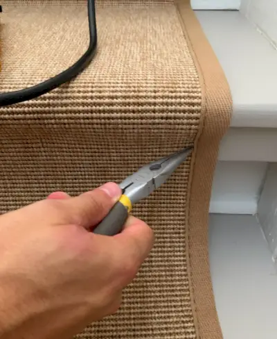 Pince à bec effilé pour retirer l'agrafe d'un tapis d'escalier en sisal