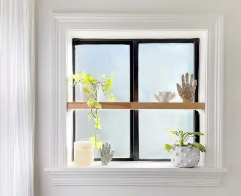 Ventana de baño esmerilada con estante de madera flotante en el alféizar