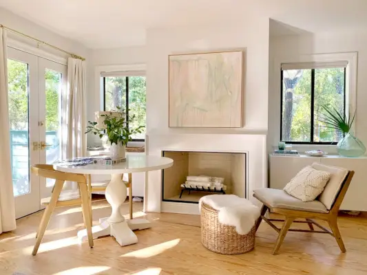 Dormitorio principal con dos ventanas junto a la chimenea y cortinas en puertas francesas.