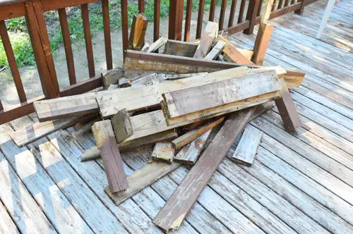 Pile de planches de terrasse cassées suite à la réparation de trous