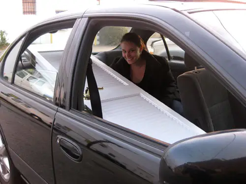 Sherry seduto sul sedile posteriore di un'auto con le porte che passano attraverso il sedile del passeggero