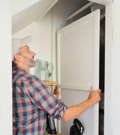 John Lifting HVAC Cover Panel Off Of Závesná tyč