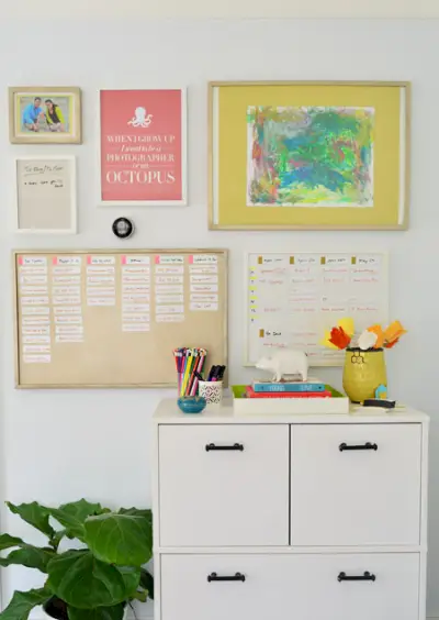 Mur de bureau peint couleur pistache pâle avec art encadré et tableaux magnétiques colorés