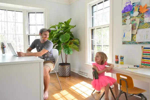 John et sa fille travaillent côte à côte dans un bureau à domicile