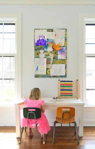 Filha para colorir em pequena mesa de arte em home office