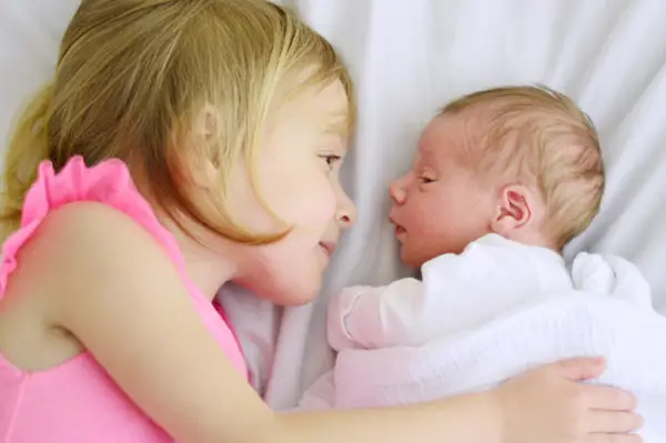 Große Schwester und kleiner Bruder Seite an Seite im Bett