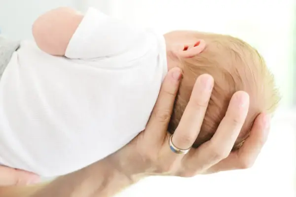 Pappa Hånd Holder Nyfødt Hode For Fødselskunngjøring Photoshoot