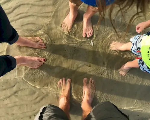 Familienfüße im flachen Wasser der Chesapeake Bay in Cape Charles