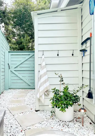 Pequeno galpão construído na lateral da casa com ganchos para toalhas