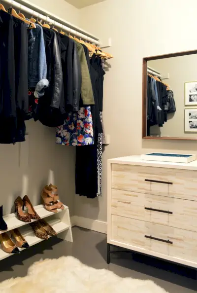 Walk in closet før oppussing med kommode og hengende klesstang