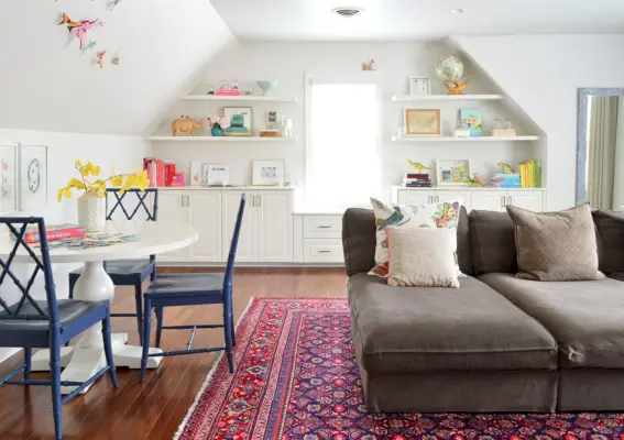 Salle de jeux familiale avec tapis traditionnel, canapé surdimensionné et étagères intégrées