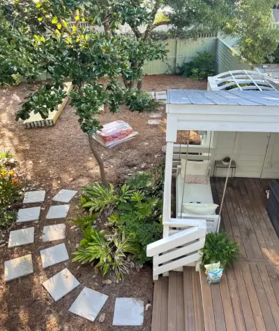 Uitzicht op tuin van bovenaf met oude heklocatie en straatstenen verplaatst