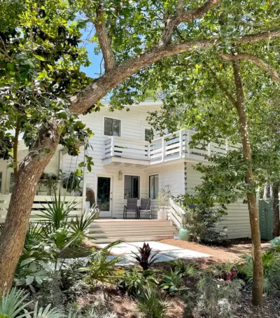 Façade d'une maison moderne blanche avec beaucoup d'angle de verdure