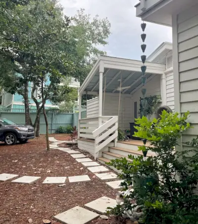 Vue latérale de la maison avec petite allée pavée en pierre devant la maison