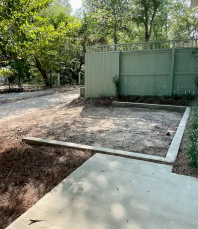 Betonmauer, die den Parkplatz durch einen Zaun markiert