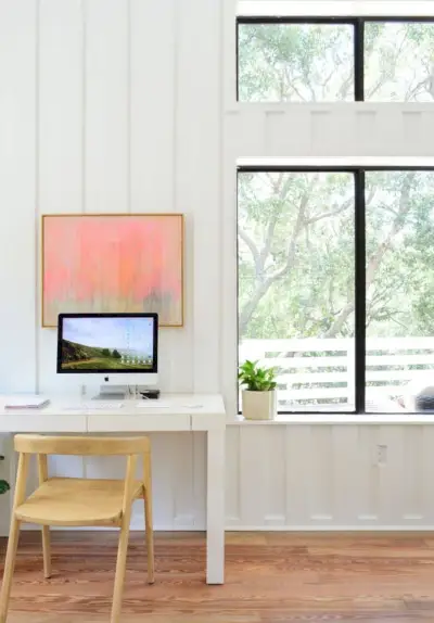 Sala de estar playera con área de oficina y paredes de tablones blancos