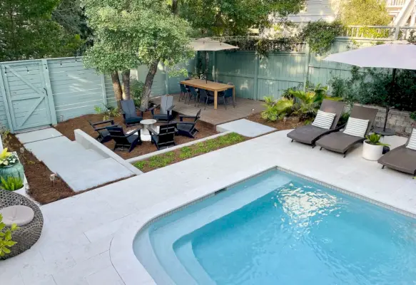 Vista dall'alto della zona piscina più grande del cortile con salotto e zona pranzo