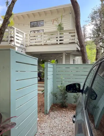 Puerta de valla abierta que muestra el acceso al aparcamiento y al porche de la cocina