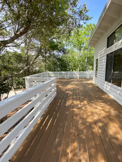 Grande terrasse extérieure sur maison blanche avec beaucoup d'arbres