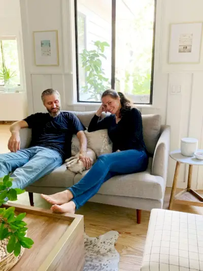 John und Sherry sitzen zusammen mit Chihuahua auf einem grauen Sofa