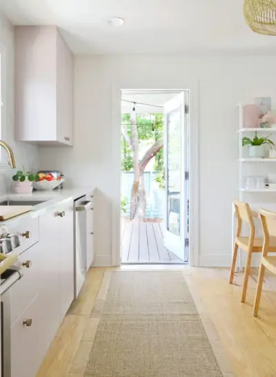 Vue de la porte ouverte sur le porche de la cuisine avec des arbres à l'extérieur