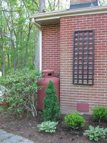 Después de la foto del tanque de propano pintado de rojo para combinar mejor con el exterior de una casa de ladrillo