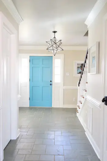 Foyer con porta blu e soffitto grigio Revere Pewter Benjamin Moore e pareti greige Edgecomb Grey