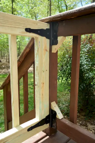 Des blocs de rebut de bois ajoutés à la balustrade pour donner un endroit sûr pour ajouter des charnières